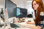 woman looking at computer monitors